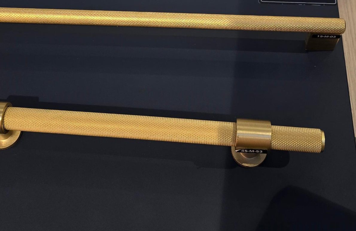 Knurled brass handles laid on midnight navy joinery
